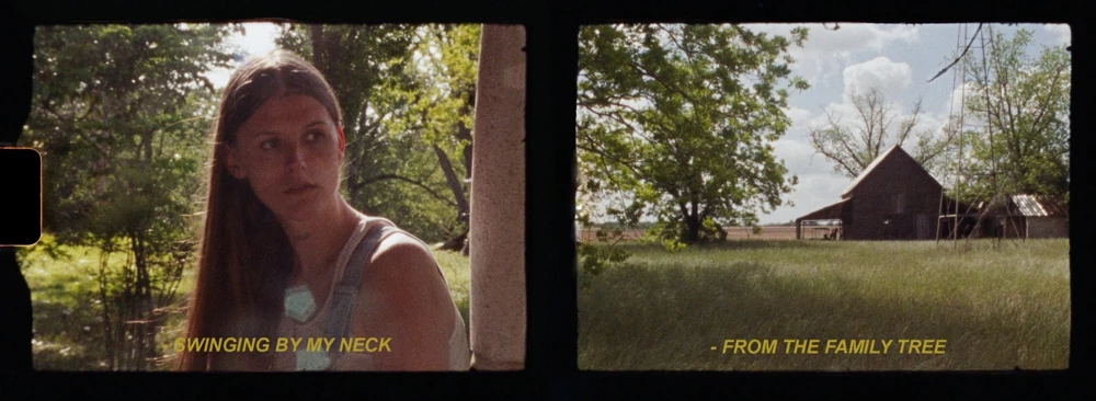 Preacher's Daughter era, Family Tree film still, under the trees in overalls, and a barn across the field